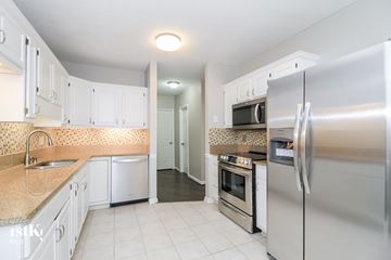 Greensboro house for rent - a kitchen with white cabinets and stainless steel appliances