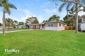 Oakland Park house for rent - a house with a yard and palm trees