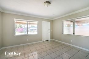 Oakland Park house for rent - an empty living room with two windows and a door