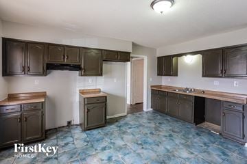 Memphis house for rent - a kitchen with dark cabinets and a sink and a counter top
