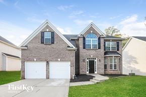 Charlotte house for rent - a brick house with two garage doors and a lawn