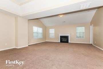 Charlotte house for rent - a living room with a fireplace and beige walls and carpet