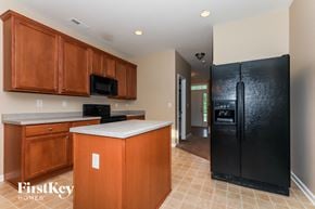 Charlotte house for rent - a kitchen with black appliances and wooden cabinets