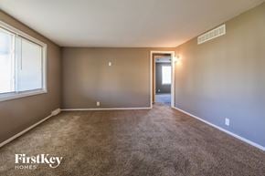 Kansas City house for rent - an empty living room with carpet and a door to a hallway