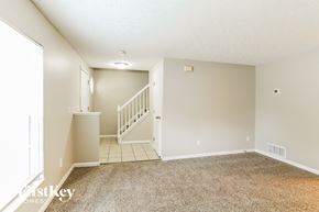 Columbus house for rent - A carpeted room with a staircase leading to the second floor.