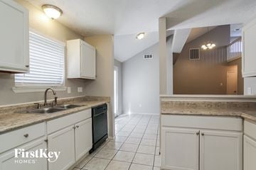 Spring house for rent - A kitchen with white cabinets and a sink.
