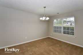 College Park house for rent - A room with a carpeted floor and a chandelier hanging from the ceiling.