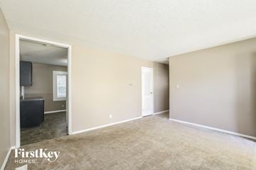 Indianapolis house for rent - a living room with carpet and a door to a kitchen