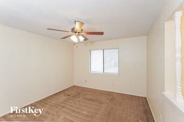 Grand Prairie house for rent - a living room with a carpet and a ceiling fan