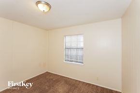 Grand Prairie house for rent - a bedroom with white walls and carpet and a window