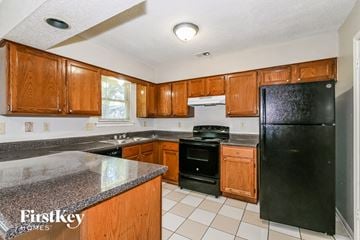 Memphis house for rent - a kitchen with black appliances and wooden cabinets