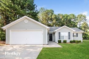 Gainesville house for rent - a white house with a white garage door and a lawn