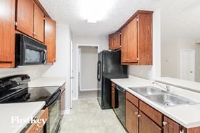 Gainesville house for rent - a kitchen with black appliances and wooden cabinets