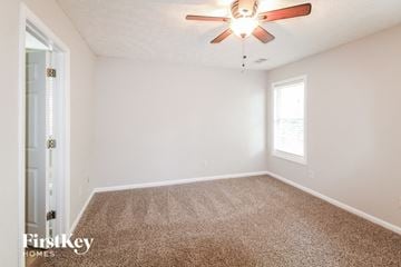 Gainesville house for rent - the spacious living room of our studio apartments atrium with ceiling fan and carpet