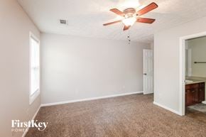 Gainesville house for rent - a bedroom with a ceiling fan and a bathroom