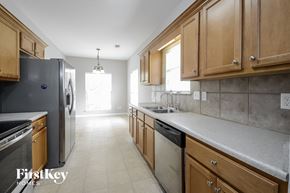 Bessemer house for rent - a kitchen with wooden cabinets and stainless steel appliances