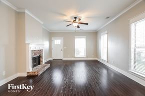 Bessemer house for rent - an empty living room with a ceiling fan and a fireplace