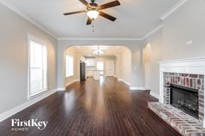 Bessemer house for rent - an empty living room with a fireplace and a ceiling fan