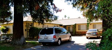 Campbell triplex for rent - A silver minivan is parked on a driveway in front of a house.