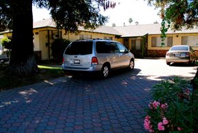 Campbell triplex for rent - Front entrance driveway with a van parked in front a yellow house with green trim and a large tree located in the front left of the yard Prodesse Property Group 1070 & 1072 Arroyo Seco Drive Campbell