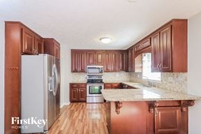 Marietta house for rent - a kitchen with wooden cabinets and stainless steel appliances and a marble counter top