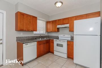 Oakland Park house for rent - a kitchen with white appliances and wooden cabinets