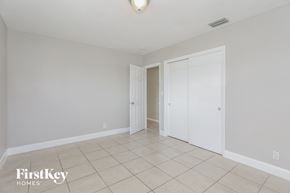Oakland Park house for rent - a master bedroom with a tiled floor and a closet