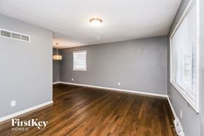 Kansas City house for rent - A room with wooden floors and a window with blinds.
