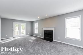 Greensboro house for rent - a living room with a fireplace and a carpeted floor