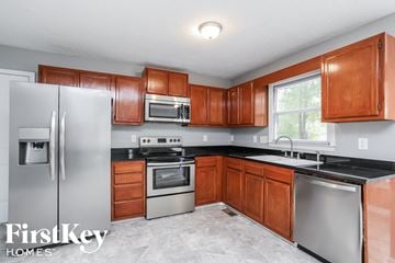 Greensboro house for rent - a kitchen with wooden cabinets and stainless steel appliances