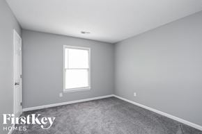 Greensboro house for rent - a bedroom with gray walls and a window and carpet