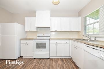 Garland house for rent - a white kitchen with white appliances and white cabinets