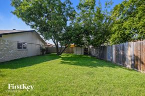 Garland house for rent - a backyard with a fenced in yard and trees