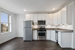 Chicago apartment for rent - a kitchen with white cabinets and stainless steel appliances
