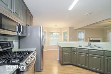 Greensboro house for rent - A kitchen with a stove top oven and a refrigerator.