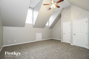 Greensboro house for rent - A spacious room with a ceiling fan and two doors.
