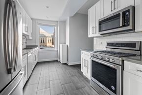Chicago apartment for rent - a kitchen with white cabinets and stainless steel appliances