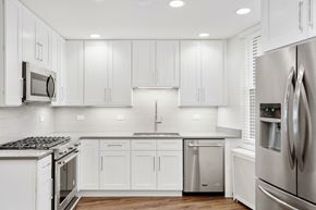 Chicago apartment for rent - a white kitchen with stainless steel appliances and white cabinets