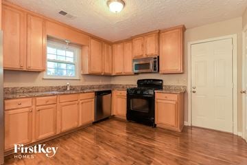 Acworth house for rent - a kitchen with wooden cabinets and black appliances
