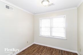 Memphis house for rent - a bedroom with white walls and wood flooring and a window