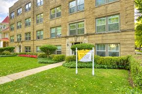 Chicago apartment for rent - an apartment building with a sign in front of a lawn
