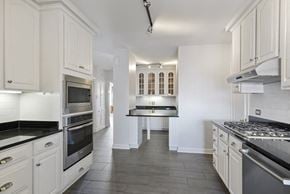 Chicago apartment for rent - a white kitchen with stainless steel appliances and white cabinets