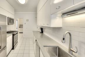 Chicago apartment for rent - a white kitchen with a stainless steel counter top and a sink