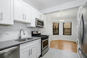 Chicago apartment for rent - a kitchen with stainless steel appliances and white cabinets