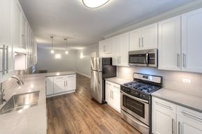 Chicago apartment for rent - a kitchen with white cabinets and stainless steel appliances