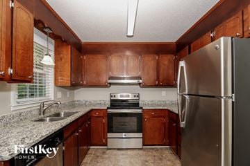 Winston-Salem house for rent - a kitchen with wood cabinets and granite counter tops and stainless steel appliances