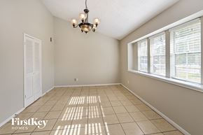 Spring house for rent - an empty dining room with large windows and a chandelier