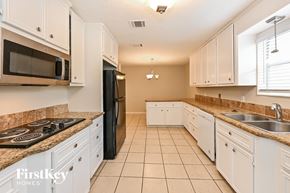 Spring house for rent - a kitchen with white cabinets and granite counter tops