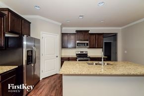 Moody house for rent - a kitchen with a granite counter top and a stainless steel refrigerator