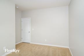 Moody house for rent - a bedroom with white walls and a white door     and a carpet